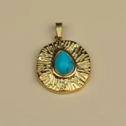 pendentif en turquoise et or sur fond